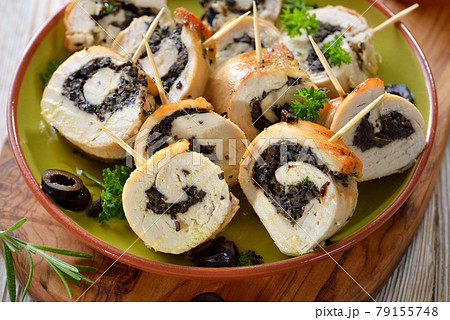 Delicious slices of chicken roll stuffed with black olives and parsley and served as finger food Delicious slices of chicken roll stuffed with black olives and parsley and served as finger food 79155748