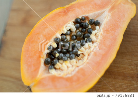 Fresh organic ripe papaya fruit cut in half on a wooden board. Exotic fruits, healthy eating concept 79156831