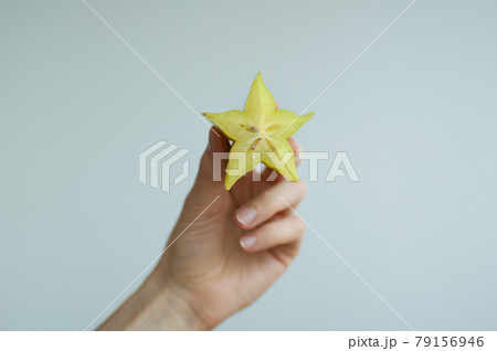 Female hands are holding slice of exotic ripe starfruit or averrhoa carambola. Healthy food, fresh organic star apple fruit Female hands are holding slice of exotic ripe starfruit or averrhoa carambola. Healthy food, fresh organic star apple fruit 79156946