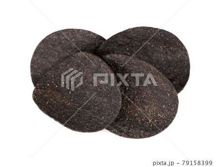 Black potato chips isolated on white background. Black chips with activated charcoal and red pepper. Black potato chips isolated on white background. Black chips with activated charcoal and red pepper. 79158399