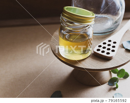 ガラス瓶に入った蜂蜜・はちみつと蜂の巣ハニーディッパー ガラス瓶に入った蜂蜜・はちみつと蜂の巣ハニーディッパー 79165592