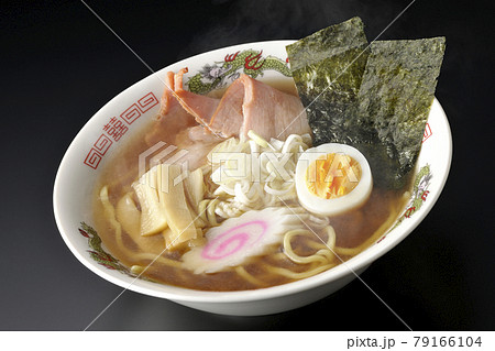チャーシューなど色々な具材が乗っている屋台で食べるような昔ながらの熱々醤油ラーメンを黒背景で撮影 79166104