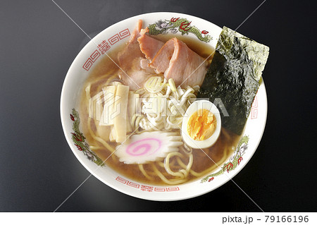 チャーシューなど色々な具材が乗っている屋台で食べるような昔ながらの熱々醤油ラーメンを黒背景で俯瞰撮影 79166196