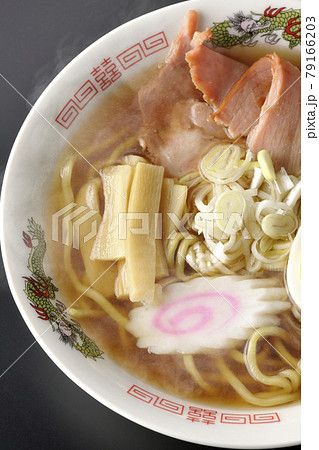 チャーシューなど色々な具材が乗っている屋台で食べるような昔ながらの熱々醤油ラーメンを黒背景で俯瞰撮影 79166203