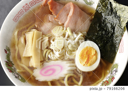 チャーシューなど色々な具材が乗っている屋台で食べるような昔ながらの熱々醤油ラーメンを黒背景で俯瞰撮影 79166206