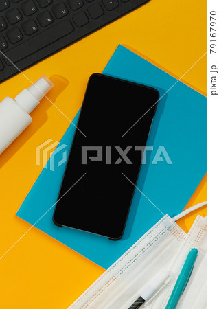 Smartphone Keyboard Stationery and Hand Sanitizer on Orange Table 79167970