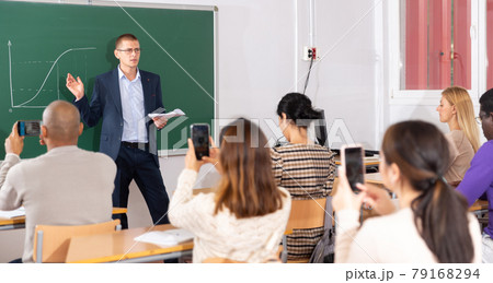 Coach giving presentation for adult audience in lecture hall Coach giving presentation for adult audience in lecture hall 79168294