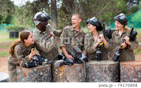 Smiling friends chatting after successful paintball match Smiling friends chatting after successful paintball match 79170808