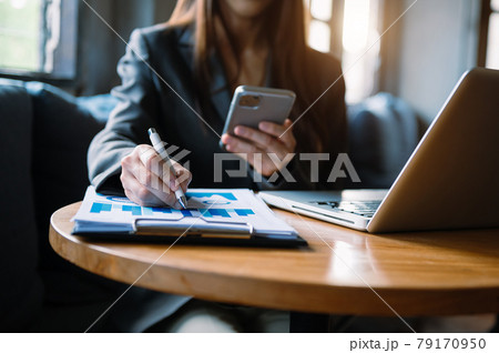 Women counting coins on calculator taking from the piggy bank. hand holding pen working on calculator to calculate on desk about cost at home office. 79170950