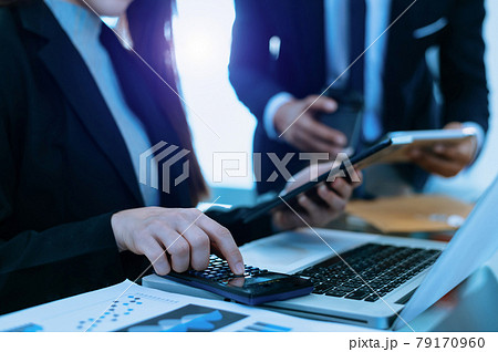 Businessman hand using smartphone, laptop and tablet with social network diagram and two colleagues discussing data on desk as concept 79170960