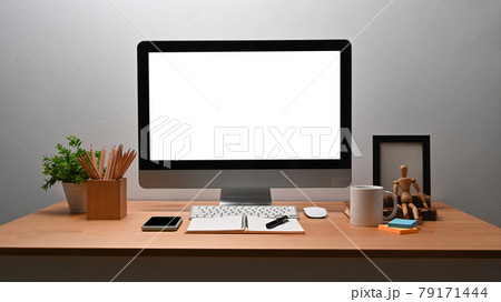 Modern workplace with computer, pencil holder and houseplant on wooden table. 79171444