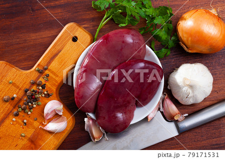 Raw pork kidneys on wooden table 79171531
