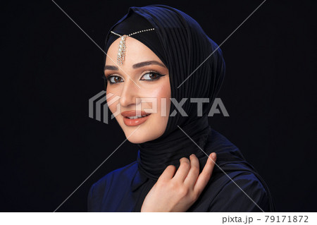 Portrait of a young muslim woman in hijab on black background Portrait of a young muslim woman in hijab on black background 79171872