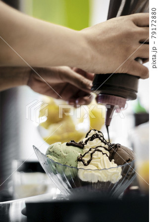 staff making italian gelato ice cream sundae in modern shop staff making italian gelato ice cream sundae in modern shop 79172880