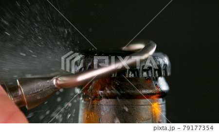 Freeze motion of opening beer bottle. 79177354