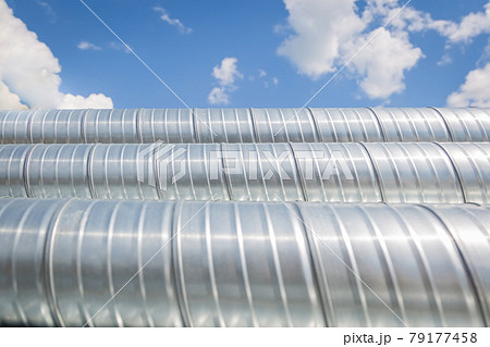 Ventilation pipes against the blue sky. Steel pipes, parts for the construction of air ducts for an Ventilation pipes against the blue sky. Steel pipes, parts for the construction of air ducts for an 79177458