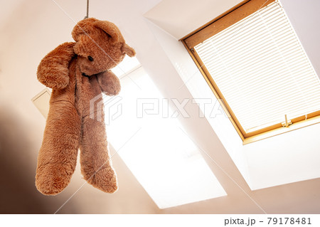 A teddy bear hanging in a noose in the attic room A teddy bear hanging in a noose in the attic room 79178481