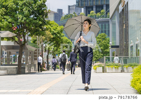 日傘をさしてビジネス街を歩くビジネスウーマン 79178766