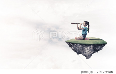 Concept of careless happy childhood with girl looking in spyglas Concept of careless happy childhood with girl looking in spyglas 79179486