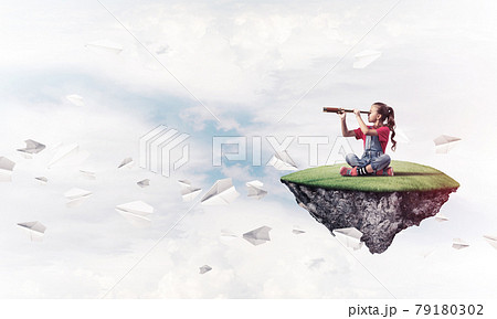 Concept of careless happy childhood with girl looking in spyglas 79180302