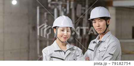 工事現場でヘルメットをかぶって微笑む男女2人のポートレート　バナーサイズ 79182754
