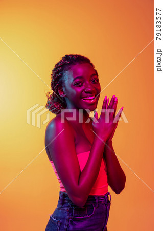 Joyful young beautiful African girl, female fashion model isolated on bright background in neon. Concept of human emotion, facial expression. 79183577