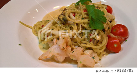 Spaghetti with shrimps, squid, tomatoes, garlic, chili, mussels, cream and parsley. 79183785