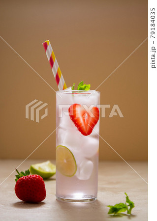 Strawberry cold drink with fresh berry, lime and mint. Summer cold drink with papper straw Strawberry cold drink with fresh berry, lime and mint. Summer cold drink with papper straw 79184035