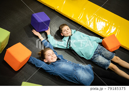 Happy smiling 11 years old kids jumping on trampoline indoors in entertainment center. Active children leisure, jumping and playing on trampoline in sport center. Amusement park. Sport activity Happy smiling 11 years old kids jumping on trampoline indoors in entertainment center. Active children leisure, jumping and playing on trampoline in sport center. Amusement park. Sport activity 79185375