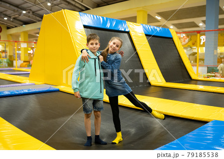 Happy smiling 11 years old kids jumping on trampoline indoors in entertainment center. Active children leisure, jumping and playing on trampoline in sport center. Amusement park. Sport activity Happy smiling 11 years old kids jumping on trampoline indoors in entertainment center. Active children leisure, jumping and playing on trampoline in sport center. Amusement park. Sport activity 79185538