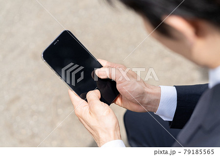 スマホを操作する若いビジネスマンの手元のアップ 79185565