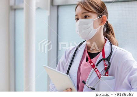 タブレットのデータを片手に考え込む若い女性医師 タブレットのデータを片手に考え込む若い女性医師 79186665