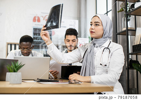 International doctors discussing results of x ray scan International doctors discussing results of x ray scan 79187058
