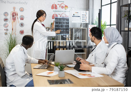Diverse doctors analyzing x ray picture during conference Diverse doctors analyzing x ray picture during conference 79187150