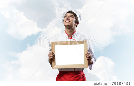 Young male chef holding blank white board 79187431