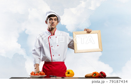 Young male chef standing near cooking table 79187434
