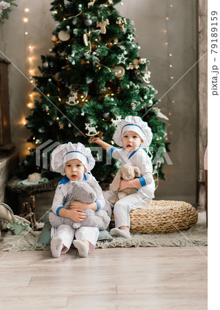Happy funny two brothers bake christmas cookies near tree. 79189159