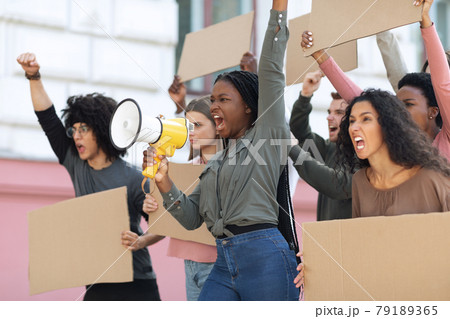 Motivated african american woman with loudspeaker over crowd 79189365