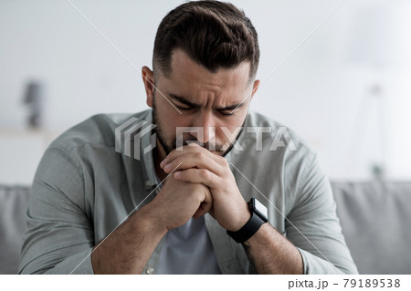 Man sit on sofa and feeling stressed at bad news, depression, loneliness Man sit on sofa and feeling stressed at bad news, depression, loneliness 79189538