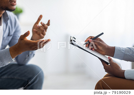 Professional psychological help concept. Unrecognizable black man talking to psychotherapist at office, closeup view Professional psychological help concept. Unrecognizable black man talking to psychotherapist at office, closeup view 79190029