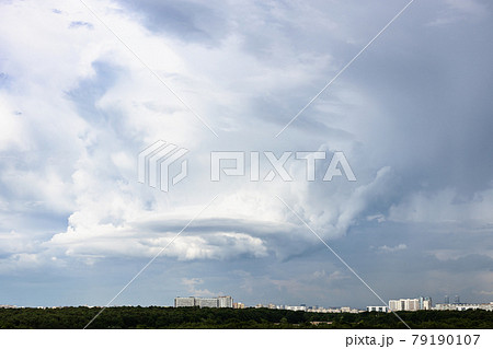 gray rainy clouds with whirls over city and forest gray rainy clouds with whirls over city and forest 79190107
