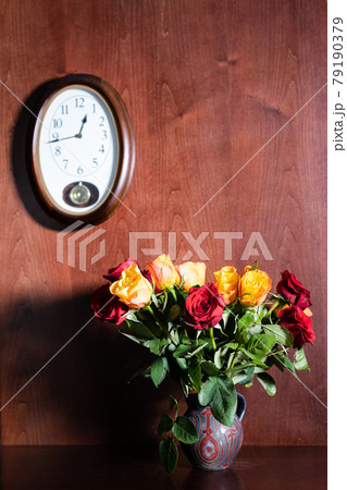 wall clock and fresh red and yellow roses in jug wall clock and fresh red and yellow roses in jug 79190379