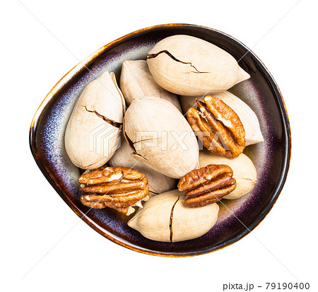 cracked and shelled pecan nuts in bowl isolated cracked and shelled pecan nuts in bowl isolated 79190400