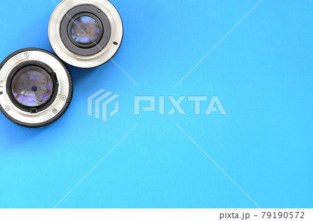 Two photographic lenses lie on a bright blue background. Space for text Two photographic lenses lie on a bright blue background. Space for text 79190572