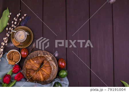 Easter breakfast with aromatic fresh espresso, croissants, colored eggs, red tulips and willow 79191004