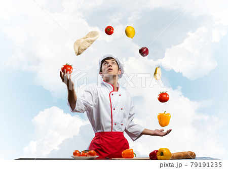 Young male chef juggles with food ingredients Young male chef juggles with food ingredients 79191235