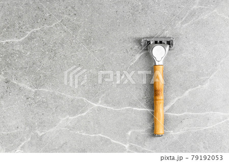 Shaving Razor with wooden handle on a grey marble Shaving Razor with wooden handle on a grey marble 79192053