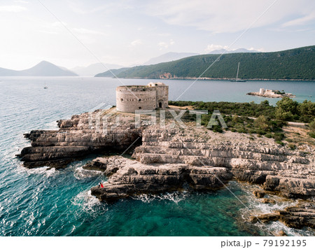 Man and woman in love stand embracing on the rocky seashore near Arza fortress Man and woman in love stand embracing on the rocky seashore near Arza fortress 79192195
