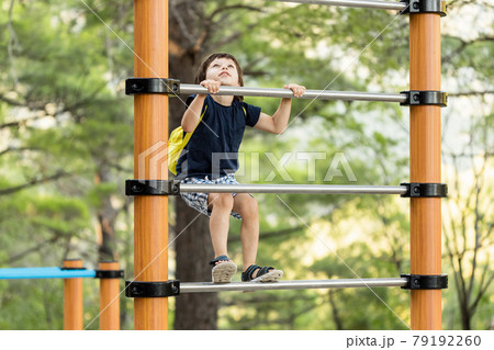 Little boy having fun playing on equipment in park Little boy having fun playing on equipment in park 79192260