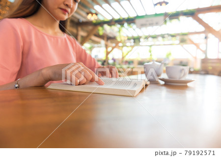 Close up of woman reading book outdoors 79192571